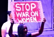 Thato wa Magogodi | Why protecting women is the foundation of African emancipation Woman during an anti-GBV protest, carries banner with words "Stop war on women".