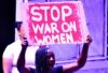 Woman holds poster written 'Stop war on women'