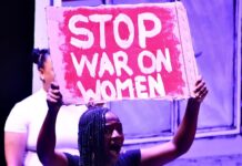 Woman holds poster written 'Stop war on women'