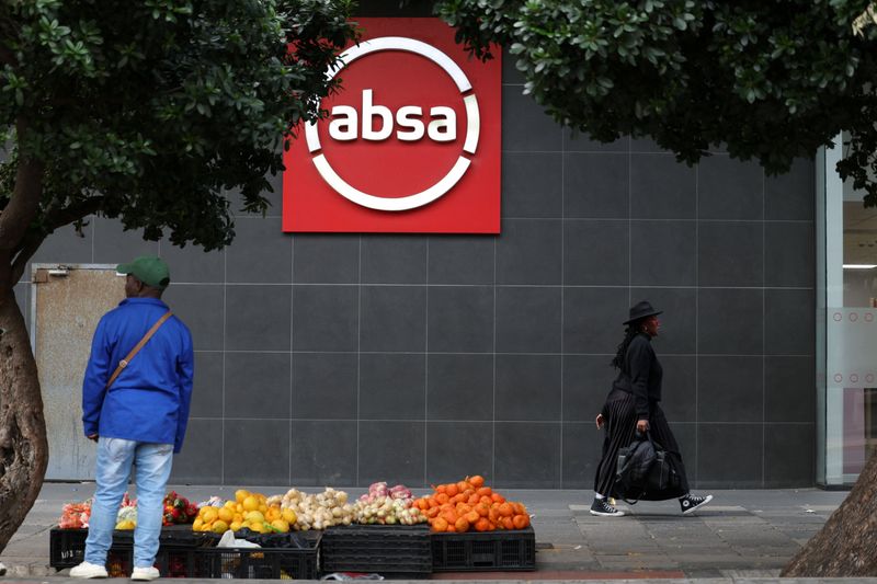 Absa bank logo on a building in Cape Town, South Africa, with a person walking by.