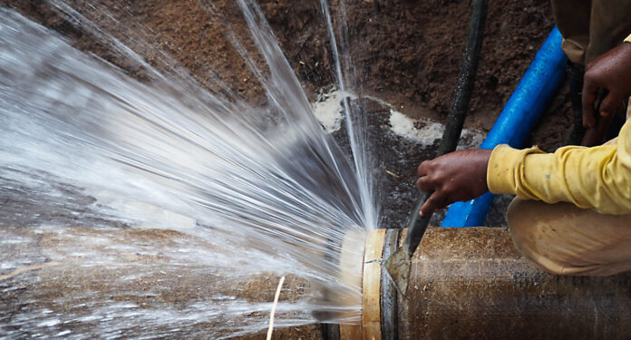 Burst water pipe leaking water due to aging municipal infrastructure in South Africa