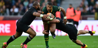Damian Willemse of South Africa tackled by George Bower of New Zealand during a rugby match at DHL Stadium.