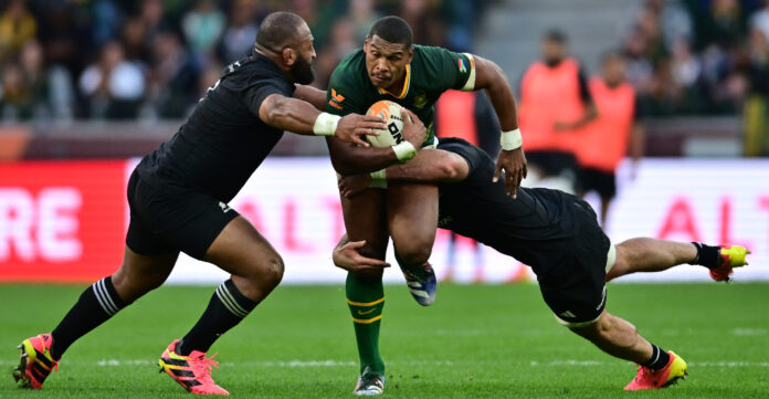 Damian Willemse of South Africa tackled by George Bower of New Zealand during a rugby match at DHL Stadium.
