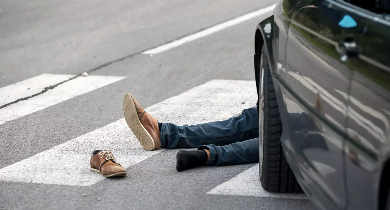 Pedestrians walking along a busy South African road near vehicular traffic