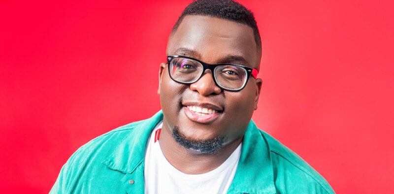 Media personality Sol Phenduka posing in a black shirt against a grey backdrop