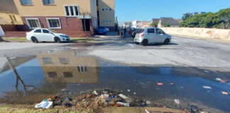 Water leaking heavily from a damaged municipal pipe running down a road in eThekwini