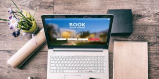 Travel consultant assisting a client with planning a holiday using a laptop