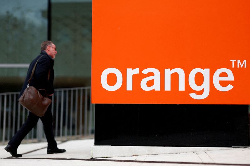 ILE PHOTO: A man walks past the logo of French telecom operator Orange at the company headquarters in Issy-les-Moulineaux near Paris, France. REUTERS/Gonzalo Fuentes/File Photo