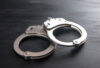 Handcuffs on dark wooden background