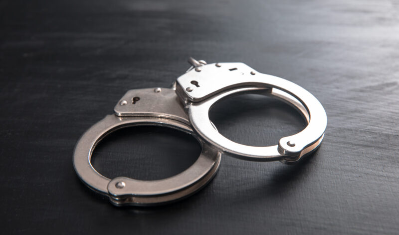 Handcuffs on dark wooden background